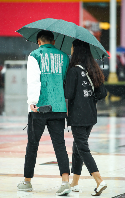 雨傘斜向小姐姐那邊,毫不在意自己肩膀被淋溼,是雨中合格男友的標準