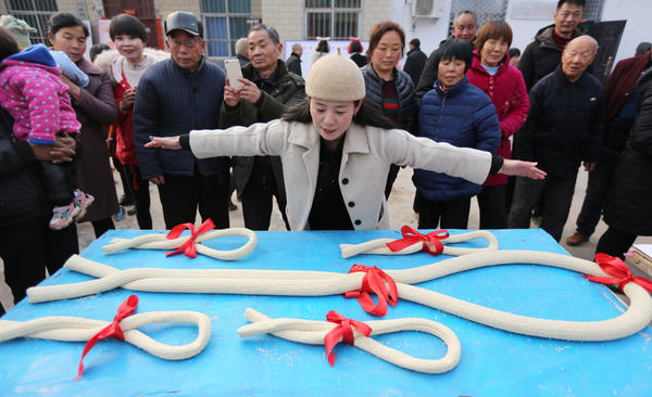 武陟县小董乡贾村,一位游客伸展双臂丈量参赛"大糖"