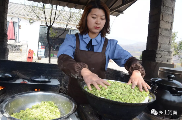 在蒸锅里添好水,魏会艳把蒸笼布打湿铺好,然后把拌好的榆钱铺到上面