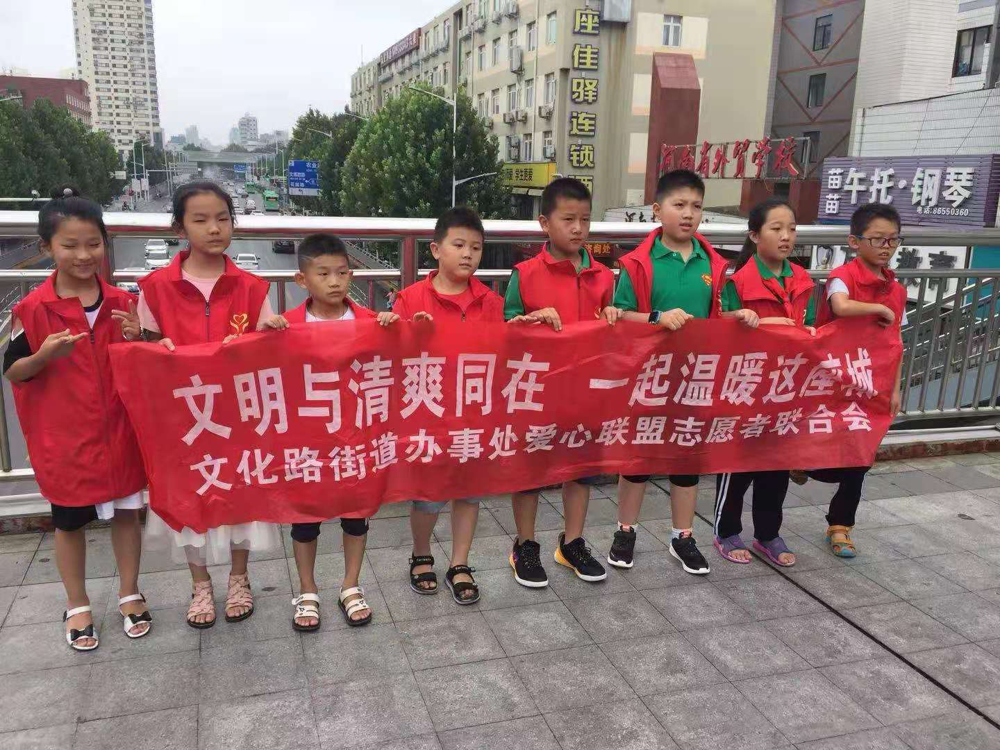 十余名小学生志愿者在家长爱的陪伴下来到文化路与农业路交叉口西南角