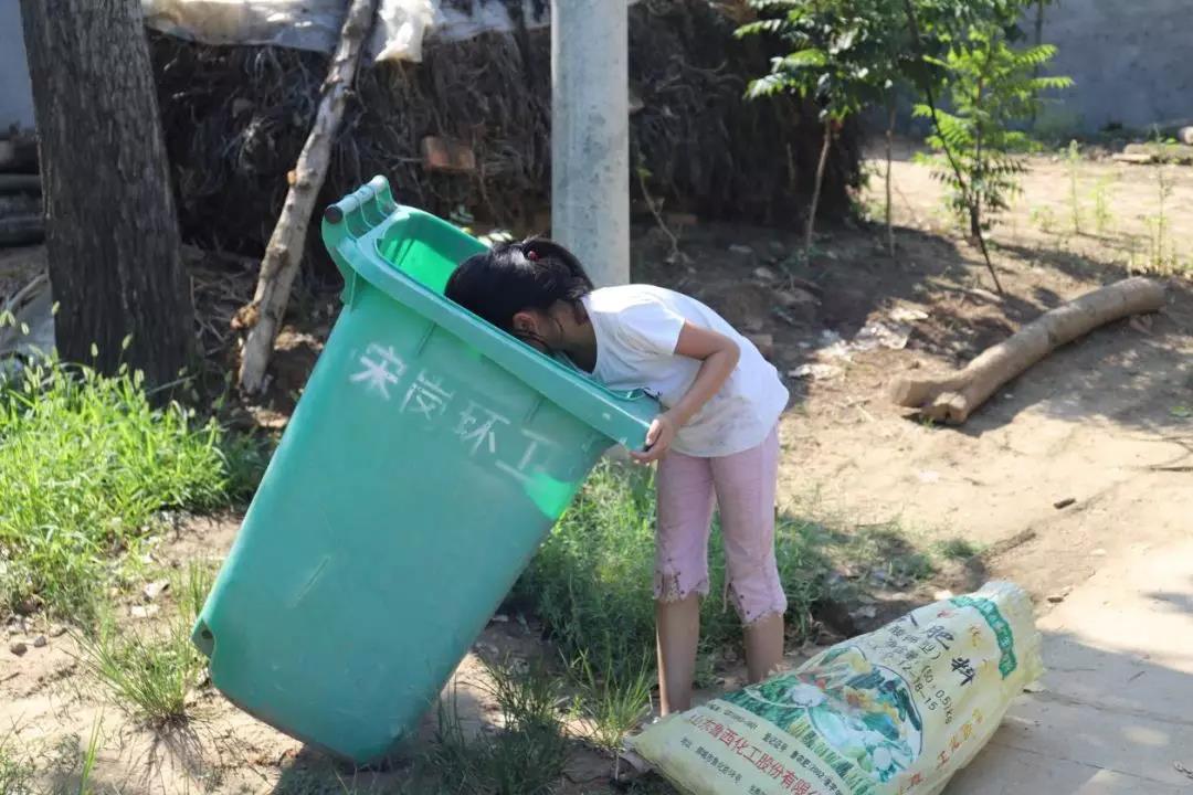 图为杜茹雪扒垃圾箱捡废品而此时,在河南驻马店新蔡县的集镇上,一个