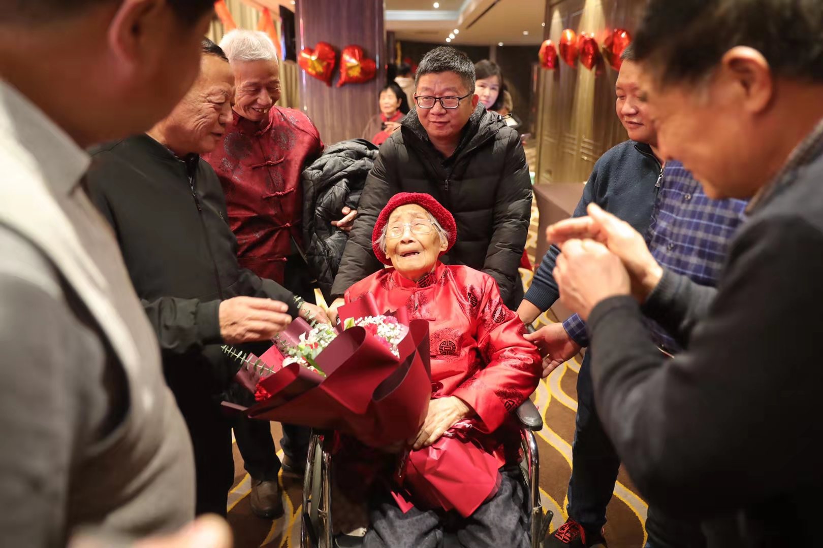 老人被亲人簇拥环抱入场