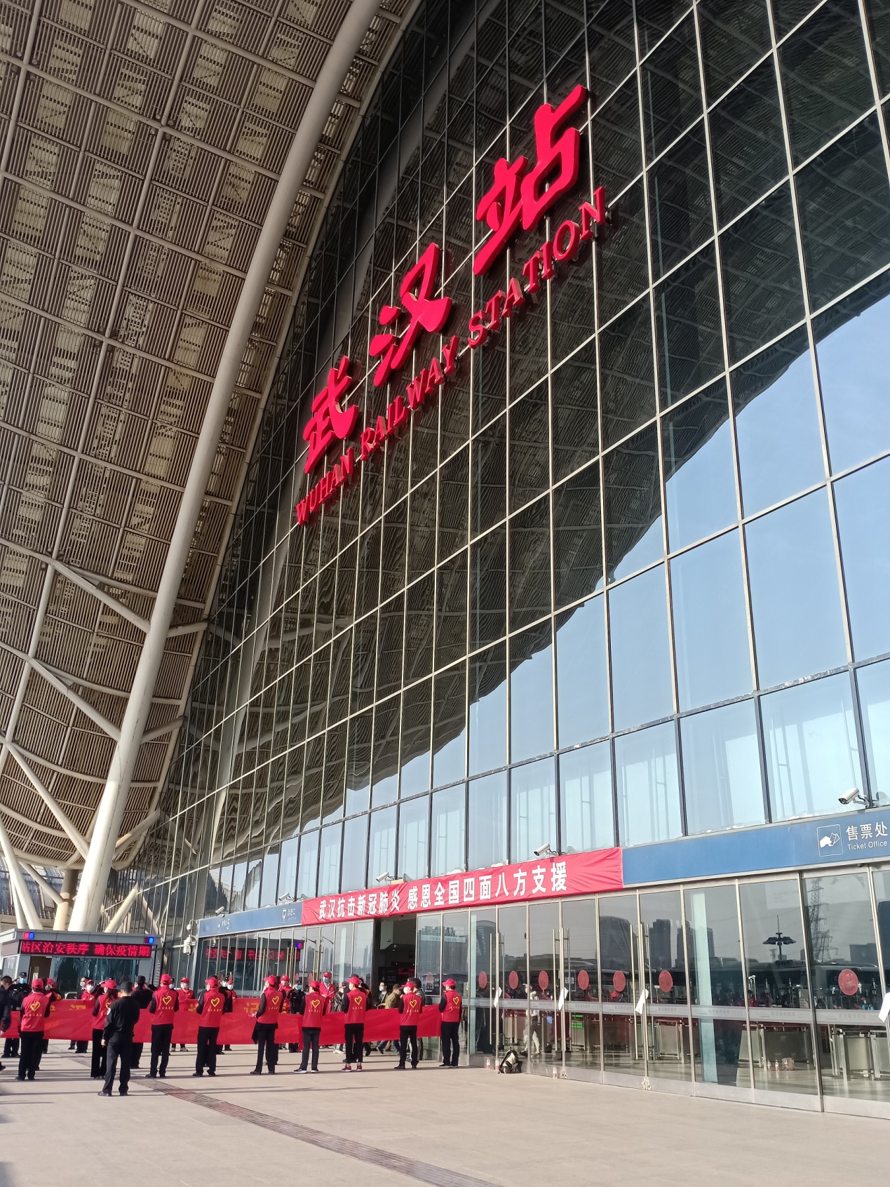 17点,车辆到达武汉车站,武汉站入口处两侧站满了身穿红色马甲的志愿者